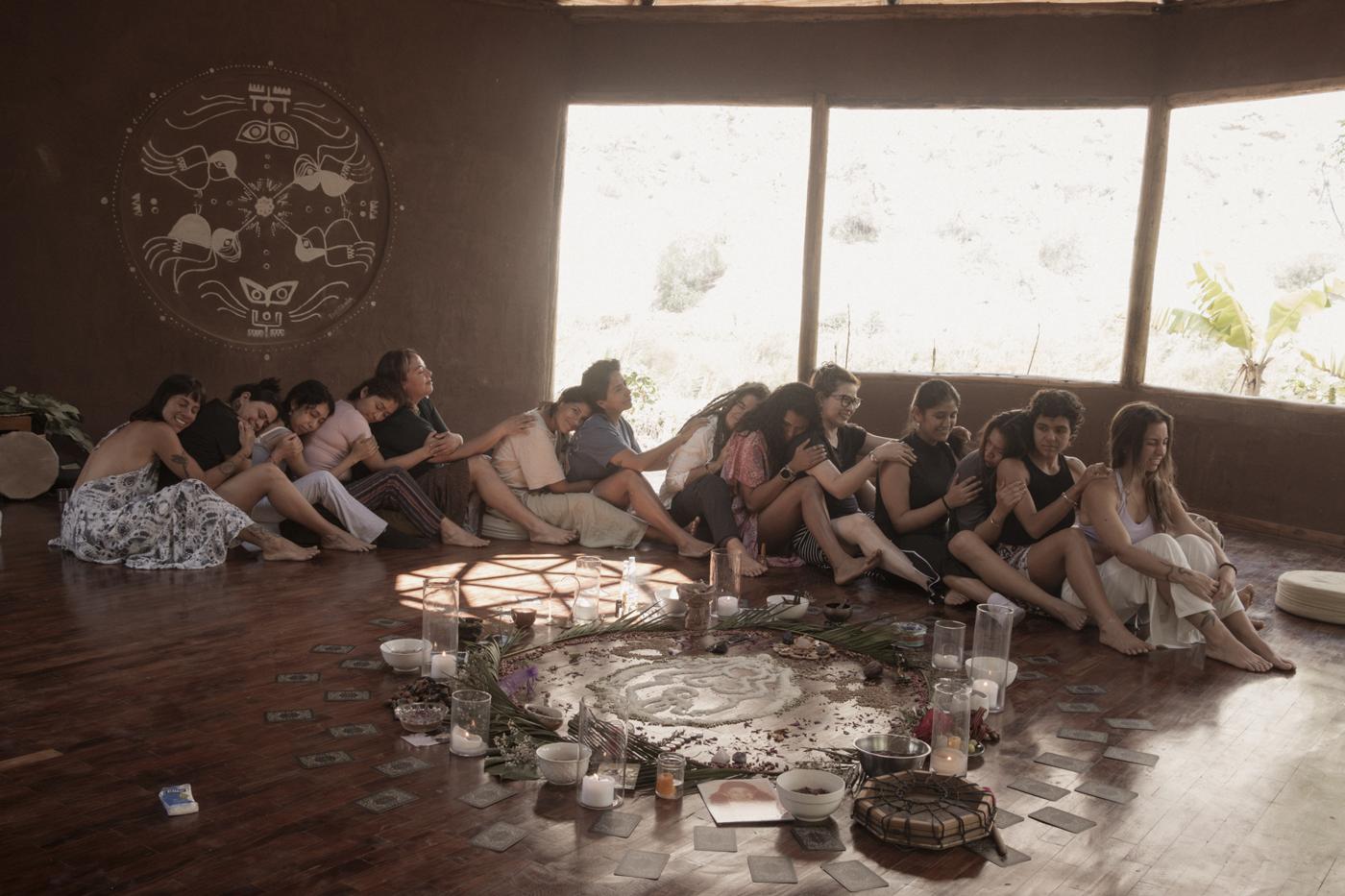 Mujeres abrazadas en un círculo alrededor de un altar