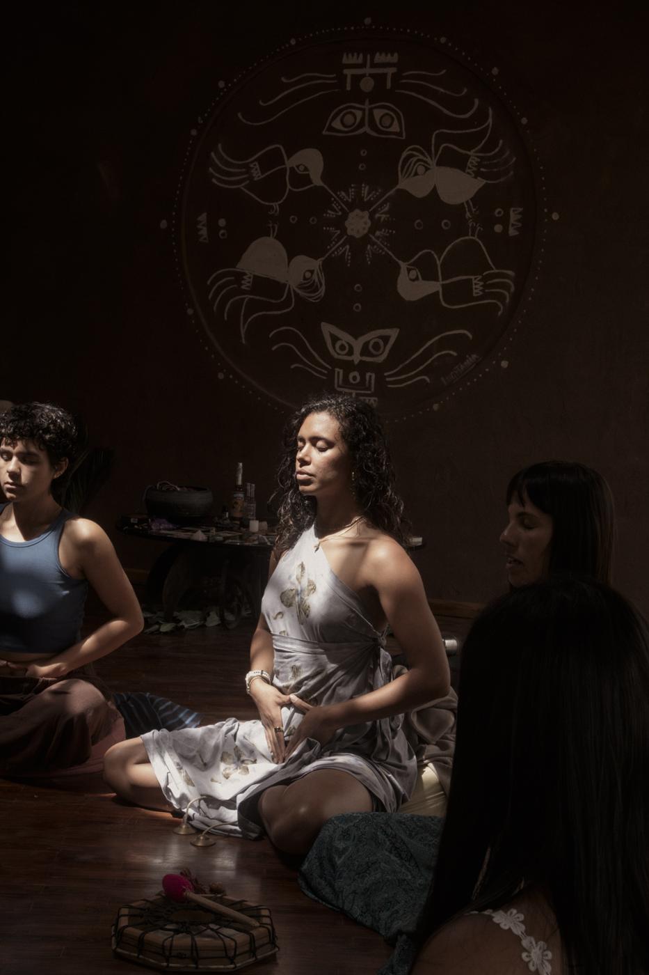 Ale meditando con las manos sobre el vientre, en un círculo de mujeres